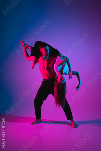 Support in gymnastics. Art. Body painting of a man and a woman, neon light