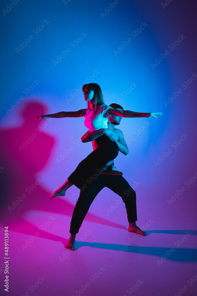 Fototapeta premium Support in gymnastics. A man holds a girl doing an exercise on weight
