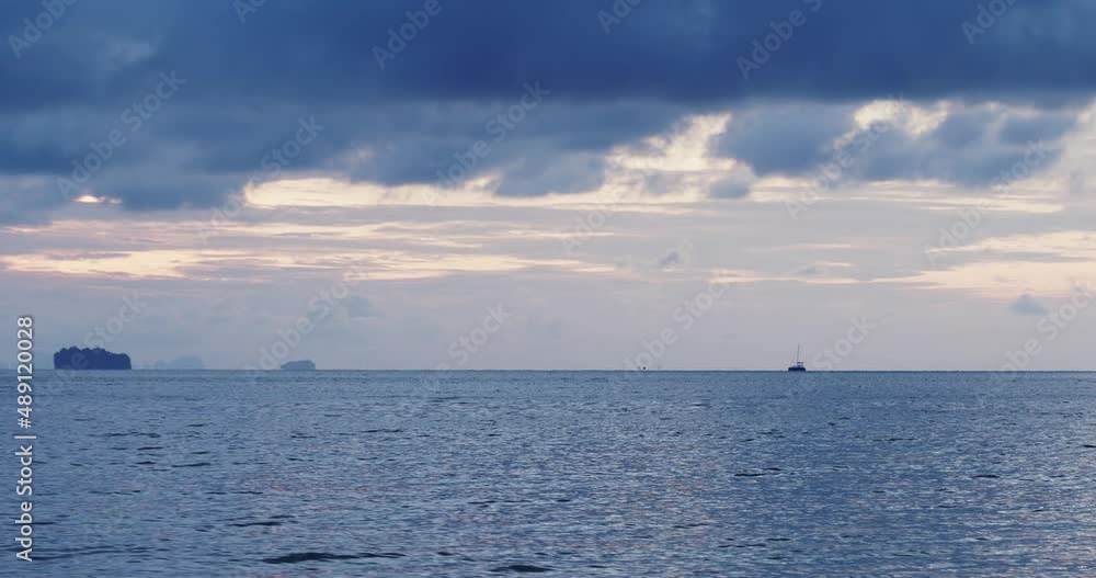 Calm sea in the evening and soft sunlight. Under the blue clouds and the ships are sailing. Phuket, Thailand. Calm sea in the evening and soft sunlight. Under the blue clouds and the ships are sailing. Phuket, Thailand.