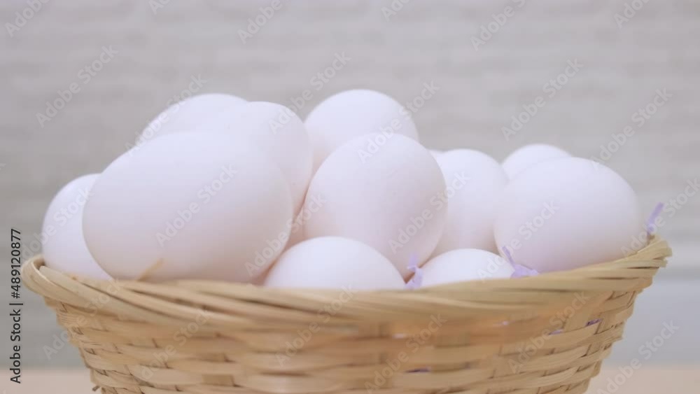 White eggs rotate in basket on light background close up. Happy Easter White eggs rotate in basket on light background close up. Happy Easter