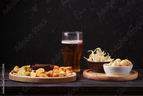 Beer snacks on a wooden table. Beer with pretzels and various snacks.