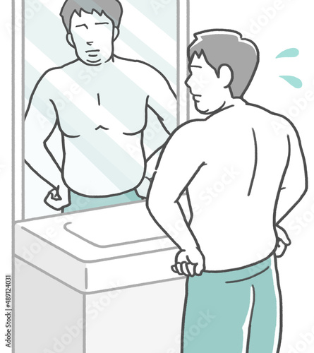鏡の前で体型をチェックし、太った事に落ち込む若い男性