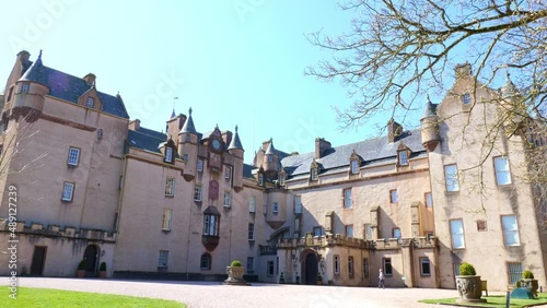 Rear view of Fyvie castle with lady walking across the courtyard photo