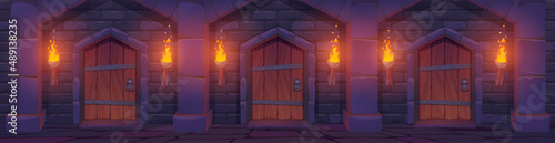 Medieval wooden doors in stone wall with arches and torches with fire. Vector cartoon illustration of corridor interior with brick wall and wood gates in ancient dungeon or castle