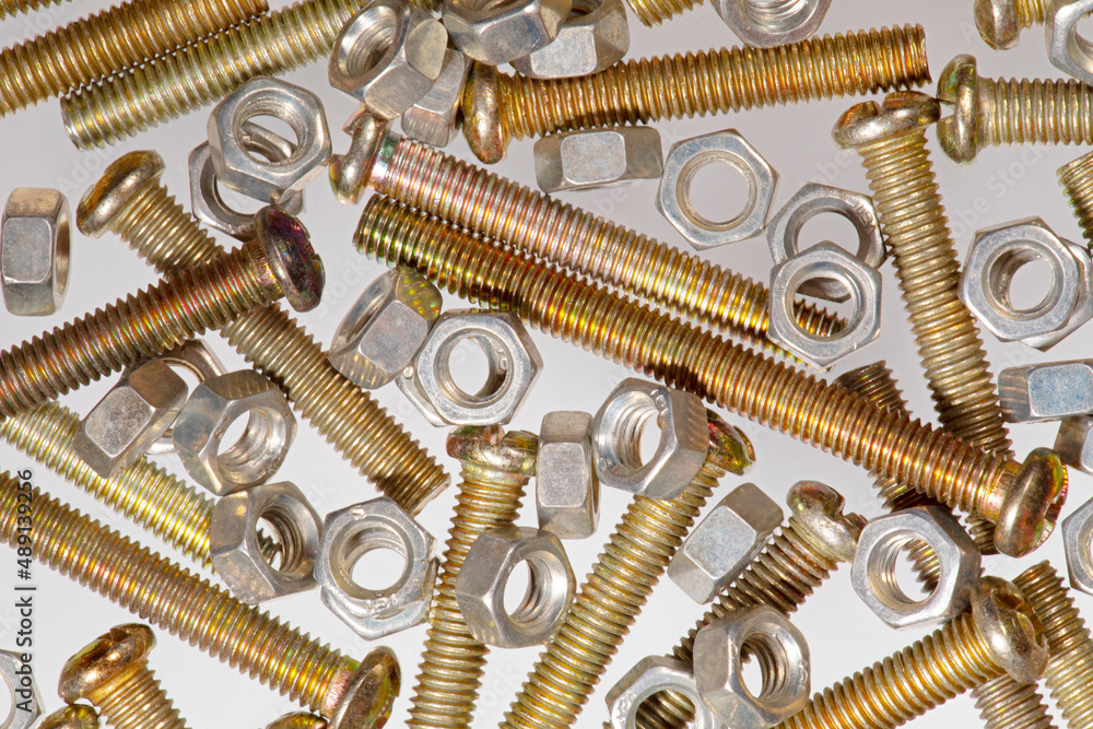 Assorted metal nuts and bolts isolated on a white background Assorted metal nuts and bolts isolated on a white background