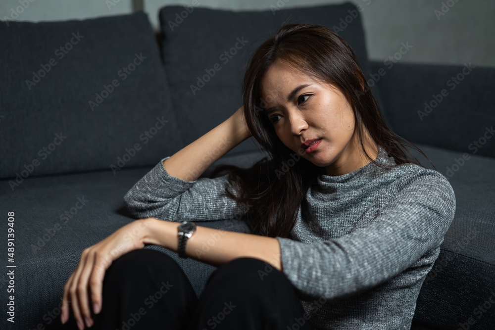 Young woman tired, sitting, depression emotion on face in dark room, looking forward, Portrait of young beautiful woman or female or girl sitting expression depression emotional alone Young woman tired, sitting, depression emotion on face in dark room, looking forward, Portrait of young beautiful woman or female or girl sitting expression depression emotional alone