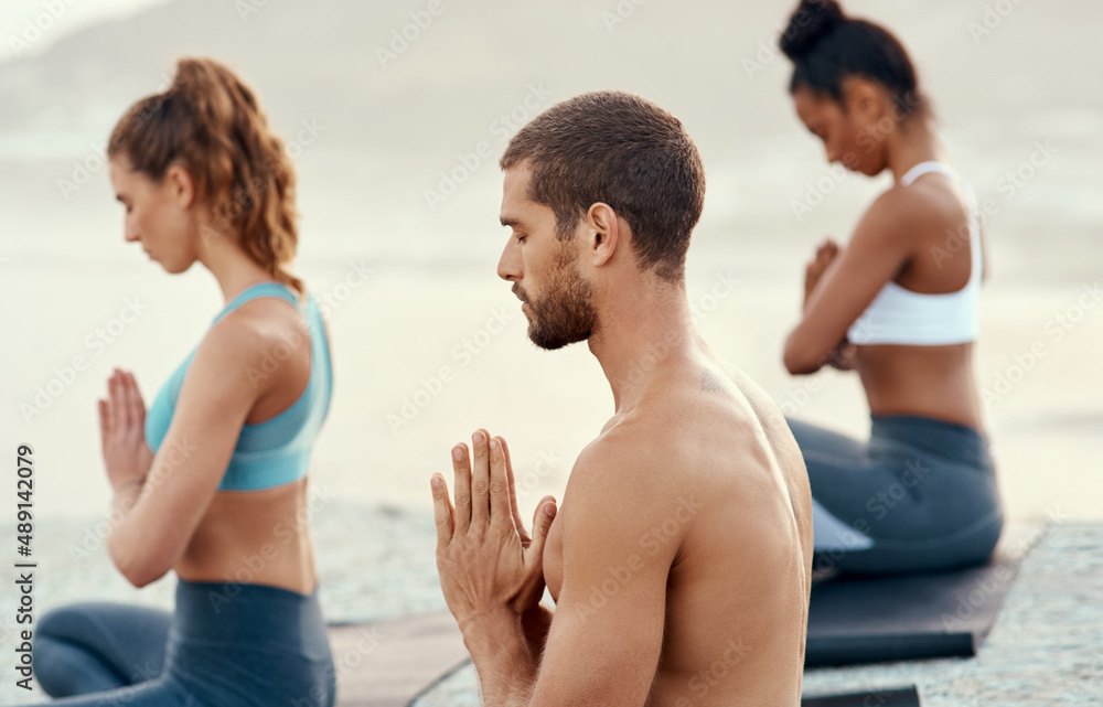Take the moment to be present and at peace. Shot of a group of young people practicing yoga together outdoors. Take the moment to be present and at peace. Shot of a group of young people practicing yoga together outdoors.