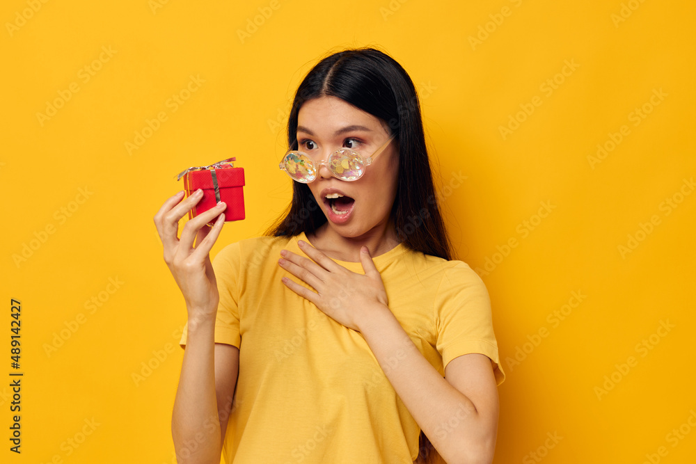 Charming young Asian woman with gift boxes in hands fun posing isolated background unaltered Charming young Asian woman with gift boxes in hands fun posing isolated background unaltered