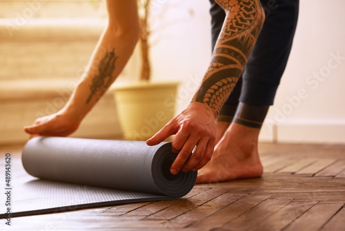 Close-up image of a man with exercise mat preparing for yoga practice