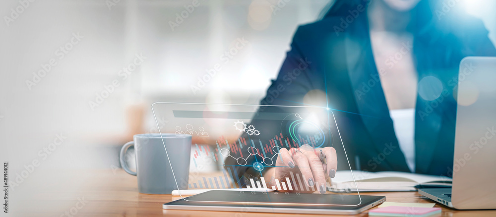 Obraz premium Businesswoman using digital tablet analyzing and developing in various information on futufistic virtual interface screen. Algorithm and marketing data analyzing.
