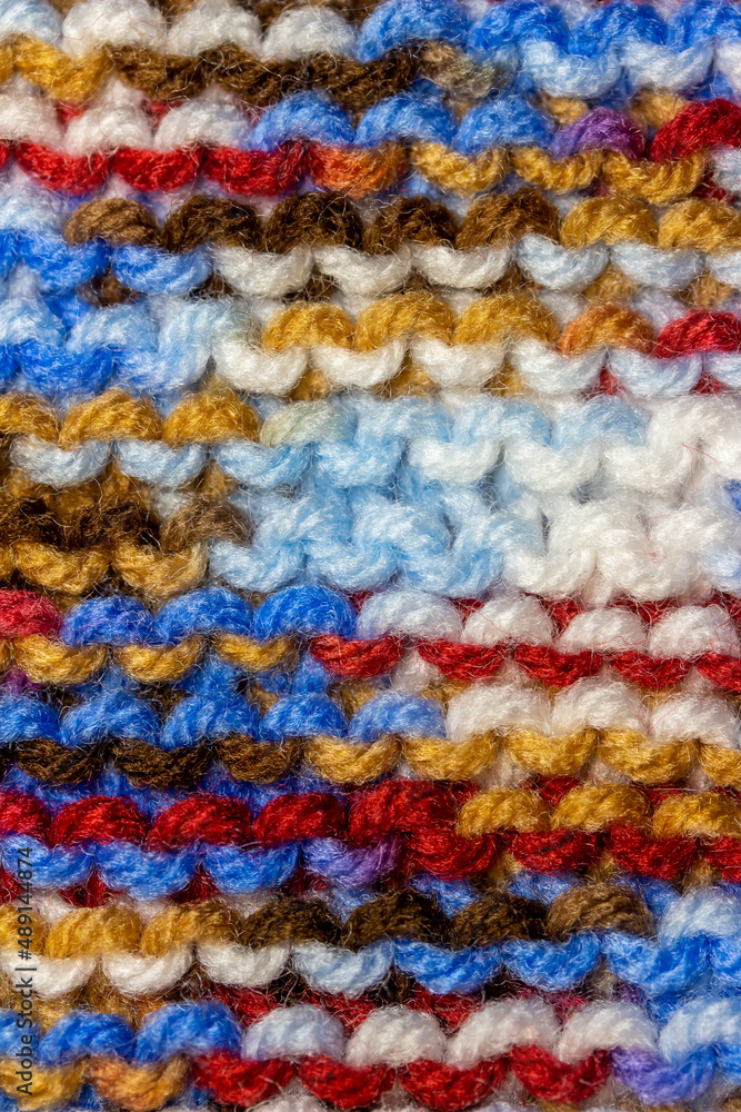 Full frame macro abstract texture background of bright colorful hand-knitted yarn cloth in a simple garter stitch
