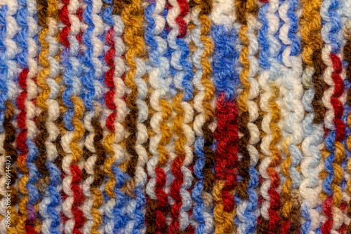 Full frame macro abstract texture background of bright colorful hand-knitted yarn cloth in a simple garter stitch © Cynthia