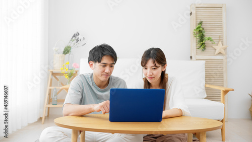 ノートパソコンを見る若い男性と女性