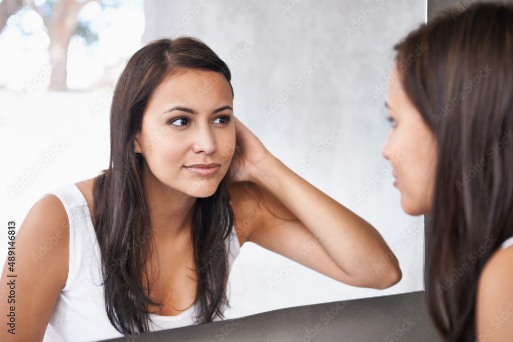 Getting excited for her date. A cropped shot of a beautiful young woman deciding on a hair style in front of her bathroom mirror. Getting excited for her date. A cropped shot of a beautiful young woman deciding on a hair style in front of her bathroom mirror.
