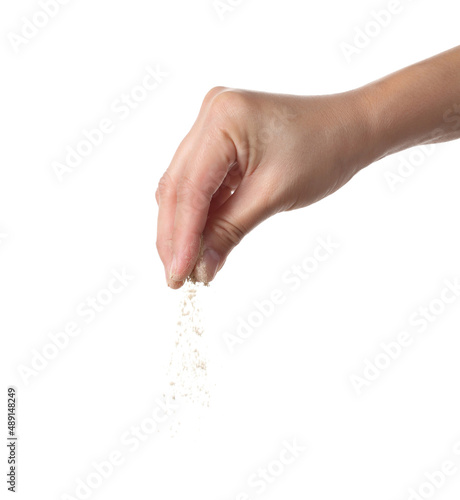 Hand holding ground pepper on white background