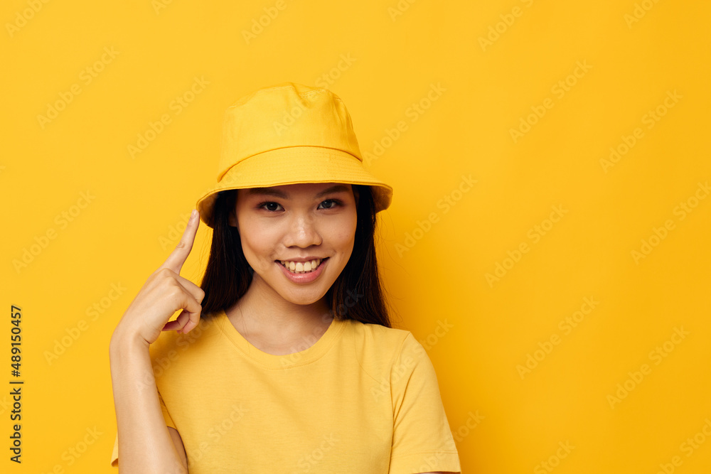 Portrait Asian beautiful young woman in a yellow t-shirt and hat posing emotions Lifestyle unaltered Portrait Asian beautiful young woman in a yellow t-shirt and hat posing emotions Lifestyle unaltered
