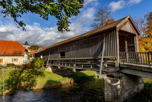 Roofed wooden bridge over the river Ilm in Buchfart, Thuringia, Germany.