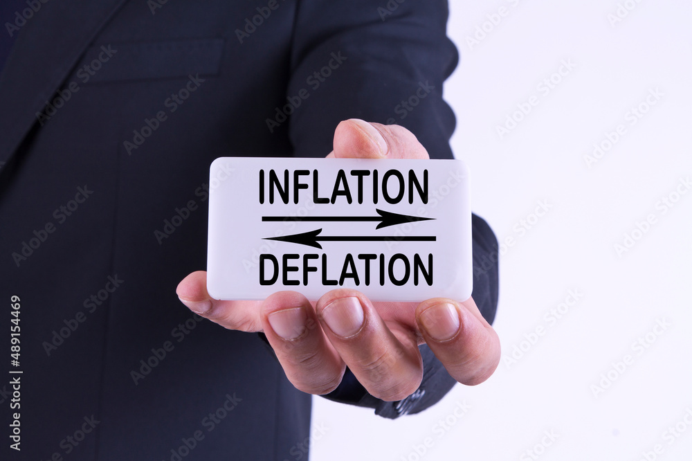 businessman holding banner with inflation and deflation concept businessman holding banner with inflation and deflation concept