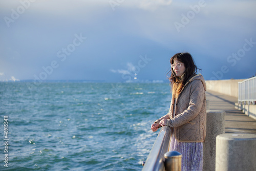 冬の海岸で散歩している若い女性の姿 © zheng qiang
