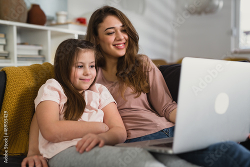 mother and daughter using laptop computer at home