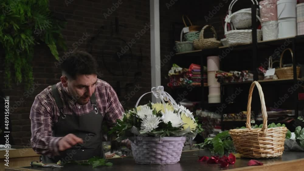 Florist checking a basket of white chrysanthemums Florist checking a basket of white chrysanthemums