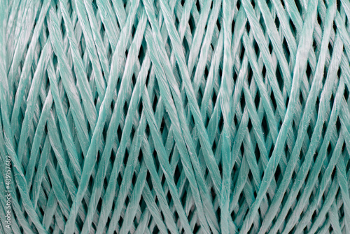 Coiled nylon rope texture background. Blue rolled striped nylon rope pattern. A coil of new colored rope surface
