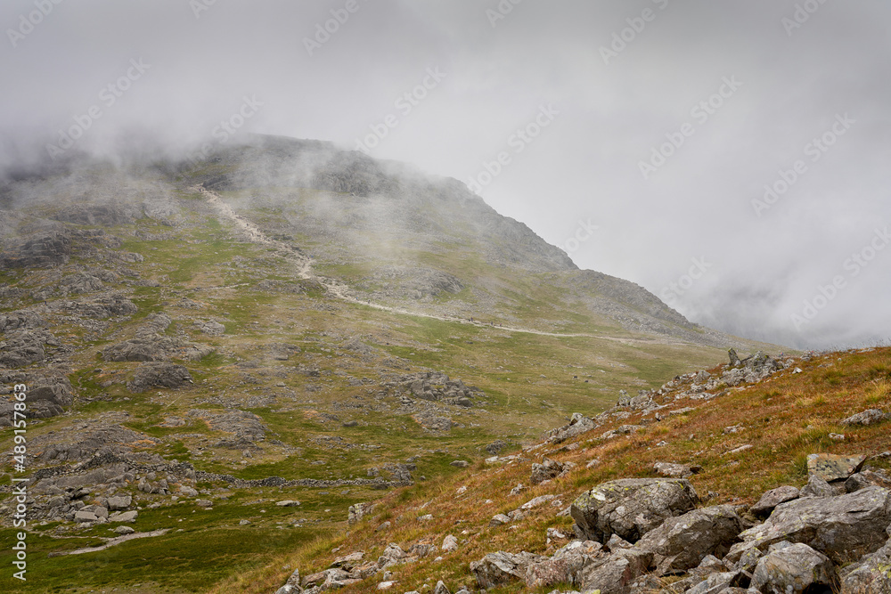 The cloud covered rocky mountain summit of Scafell Pike from the top of Lingmell in the English Lake District, UK. The cloud covered rocky mountain summit of Scafell Pike from the top of Lingmell in the English Lake District, UK.