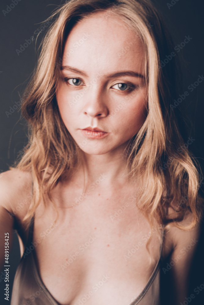 Young girl with a European Slavic appearance and brown hair, in a beige chemise, a dress with straps, playfully looks at the camera, acting skills and simple facial expressions on her face Young girl with a European Slavic appearance and brown hair, in a beige chemise, a dress with straps, playfully looks at the camera, acting skills and simple facial expressions on her face