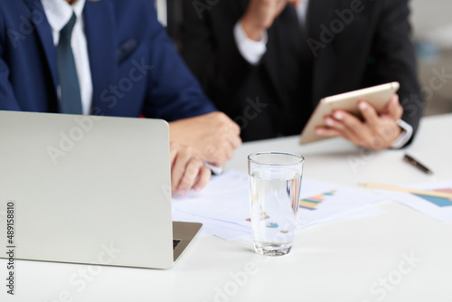 studio shot of unrecognizable unknown mentor male professional successful businessman in formal suit holding hand hugging shoulder teaching new employee analyzing report at working desk
