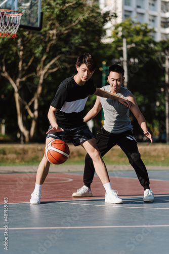 Sports and recreation concept two male basketball players enjoying playing basketball together on the sports ground