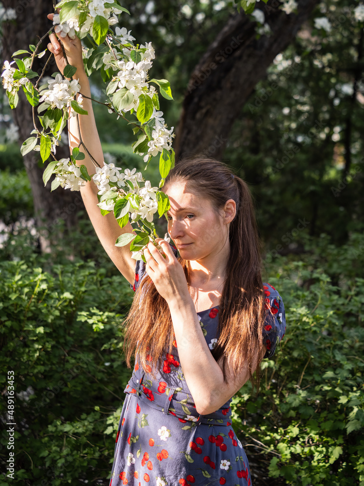 Beautiful Young woman without makeup in a spring park among flowering trees Beautiful Young woman without makeup in a spring park among flowering trees