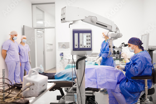 A team of medical staff and doctors working on a patient in a operating room