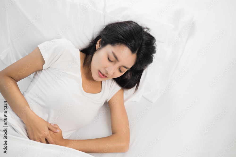 Beautiful woman stomach ache can't fall asleep, moving restless on bed at night. Young woman having period pain sleep troubles trying can not sleep. Beautiful woman stomach ache can't fall asleep, moving restless on bed at night. Young woman having period pain sleep troubles trying can not sleep.