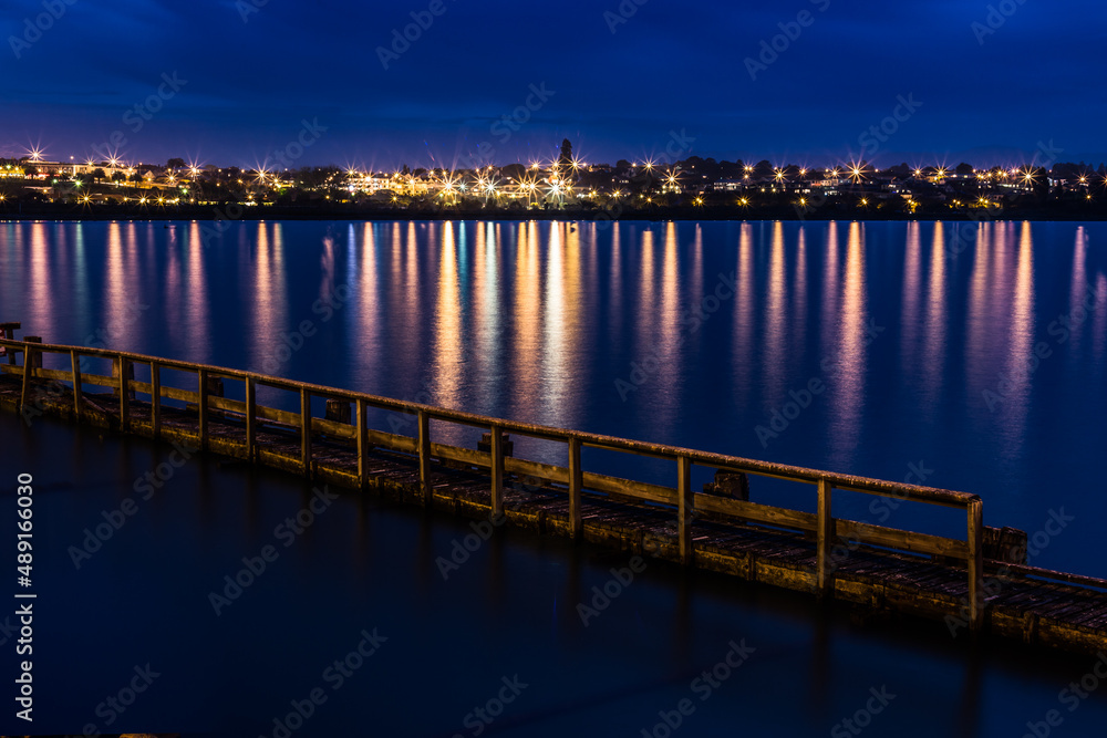 Long Exposure at  Night, Twilight Across Water, Looking at City Lights with View of Pier in Foreground. In Timaru, New Zealand