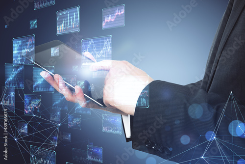 Close up of business man hands using tablet with creative forex charts on blurry background. Trade and economy concept. Double exposure.
