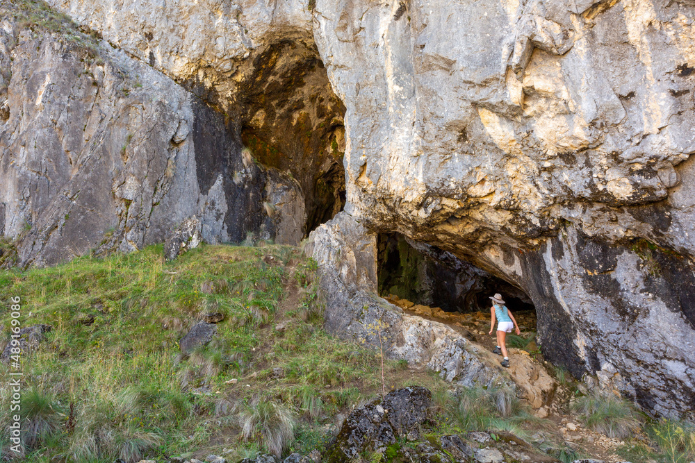 Female explorer entering a cave system in Kosziusko Mountains