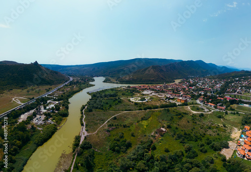 Aerial view of streets of Mtskheta village in Georgia with Mtkvari river. View of the city from the north  from Tsitsamuri