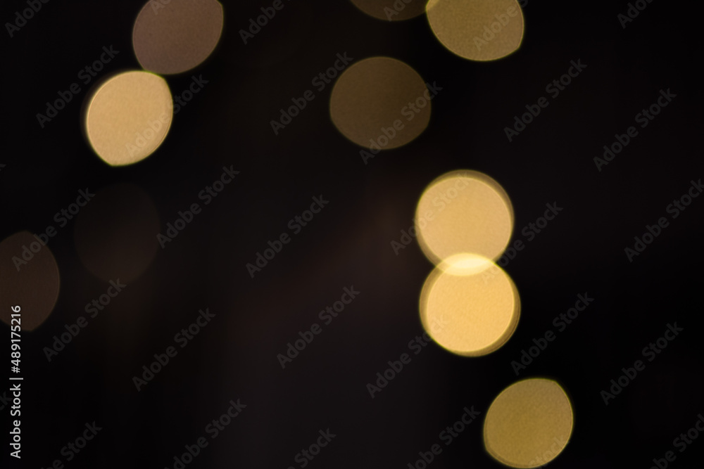 Golden abstract bokeh lights over black background. Holiday background for design. Golden abstract bokeh lights over black background. Holiday background for design.