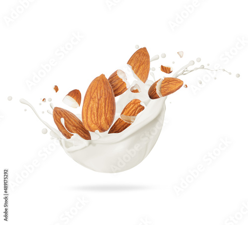 Foto Cracked almond in milk splash close-up on white background