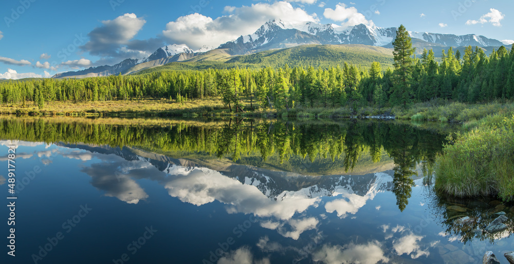 Fototapeta premium Picturesque mountain lake in the summer morning, Altai. Beautiful reflection of mountains, sky and white clouds.