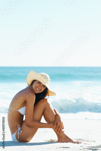 Nothing beats a day at the beach. A gorgeous young woman sitting on the beach.