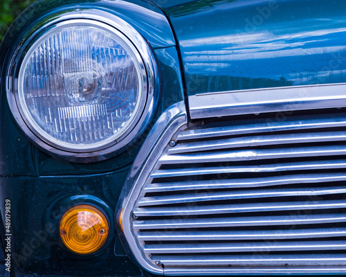 classic car partial front view with head light and chrome grille