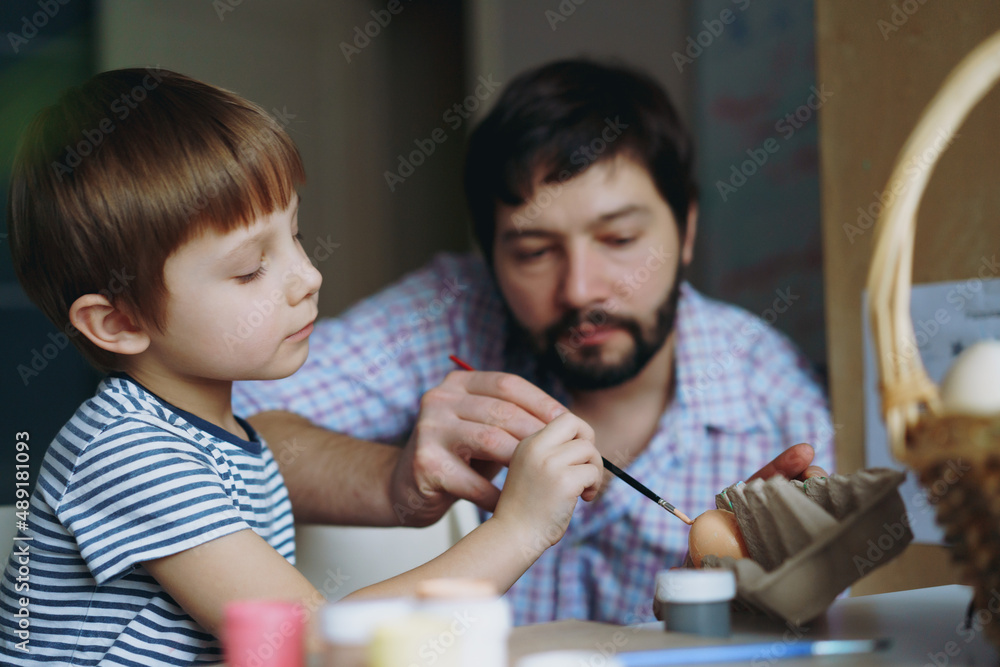 father and kid painting eggs for easter father and kid painting eggs for easter
