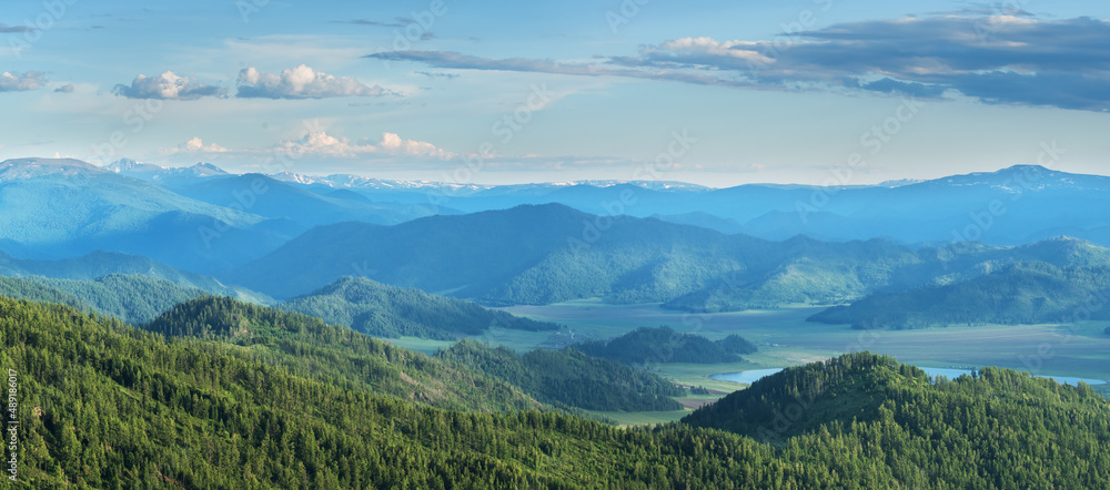 Mountain landscape, evening light, valley and peaks in a blue haze