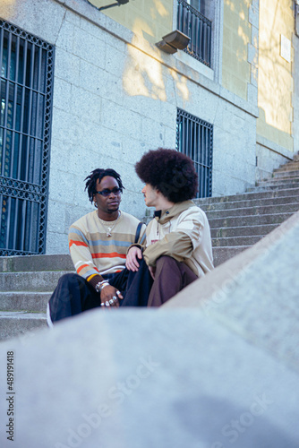 Gay couple chatting on stairs.
