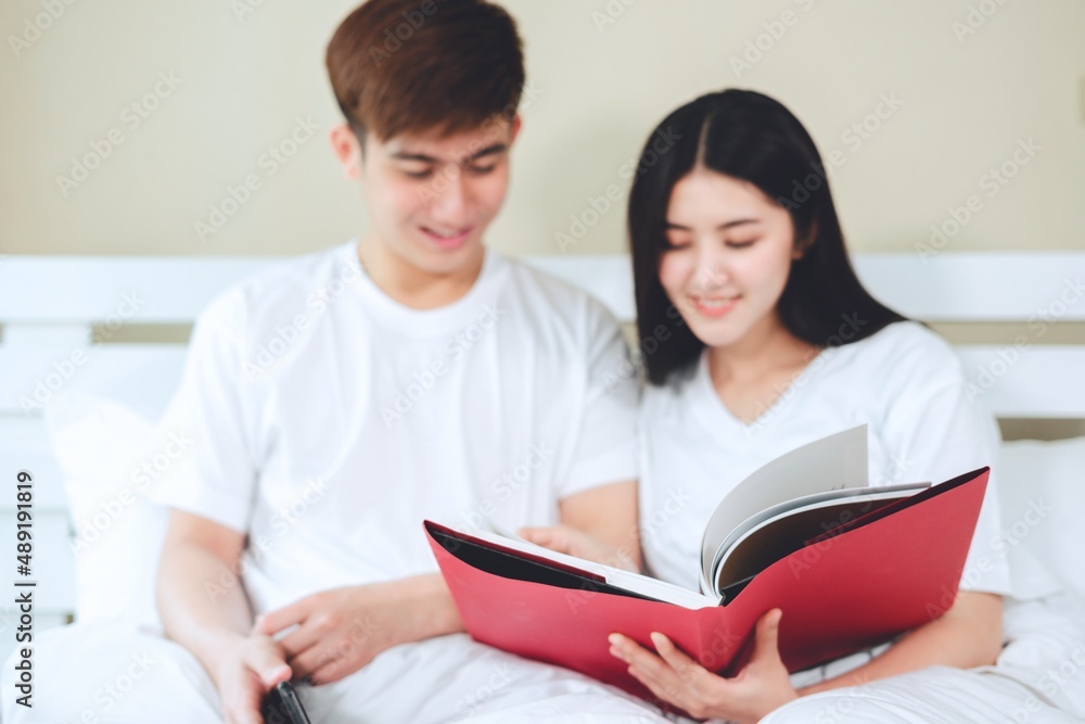 asian couples planning for future looking books, buying life insurance, buying houses, looking at wedding photos. asian couples planning for future looking books, buying life insurance, buying houses, looking at wedding photos.