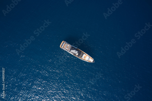 Luxurious gray blue Mega yacht on dark water top view. Big gray super boat on the water aerial view. Big yacht for millionaires in the sea drone view. © Berg