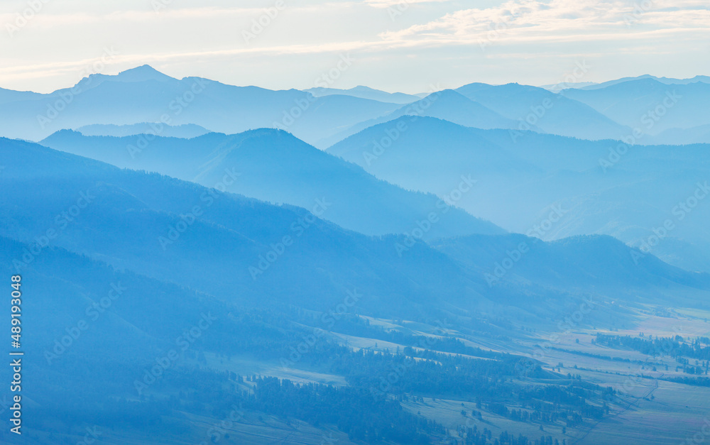 Mountains in blue haze. Morning light, valley and mountainsides. Mountains in blue haze. Morning light, valley and mountainsides.