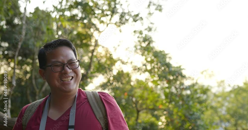 Slow motion shot, Young backpacker man in glasses greeting giving high five clapping hands with someone in forest after finished on the rocky peak Slow motion shot, Young backpacker man in glasses greeting giving high five clapping hands with someone in forest after finished on the rocky peak