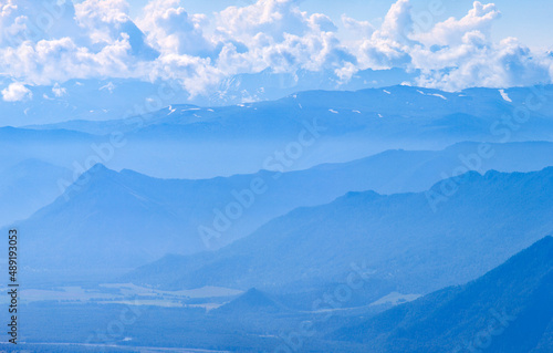 Mountains in blue haze. Morning light, valley and mountainsides.